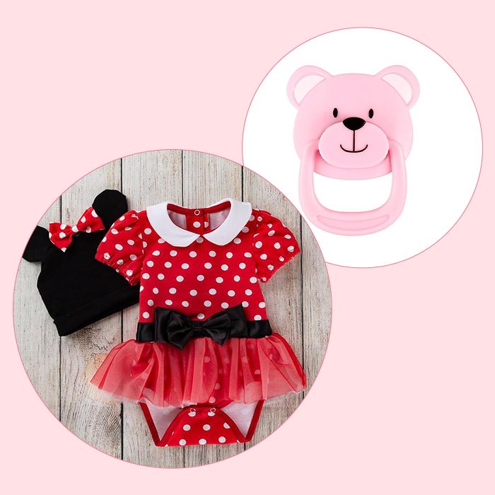 Red polka dot baby outfit with black bow, mouse ear hat, and pink bear-shaped baby rattle against a light pink background—perfect for realistic dolls or reborn babies.